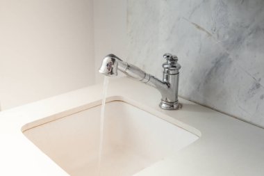 Musluktan su damlası. Modern beyaz lavabo.
