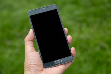 Elinde yeşil arkaplan olan akıllı telefon