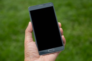 Elinde yeşil arkaplan olan akıllı telefon