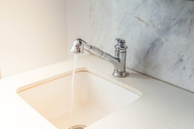 Musluktan su damlası. Modern beyaz lavabo.