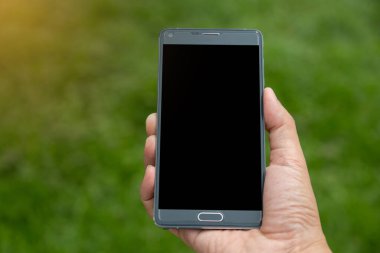 Elinde yeşil arkaplan olan akıllı telefon