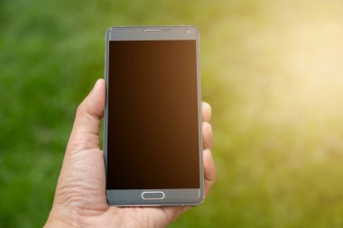 Elinde yeşil arkaplan olan akıllı telefon