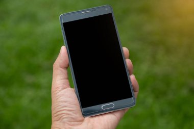 Elinde yeşil arkaplan olan akıllı telefon