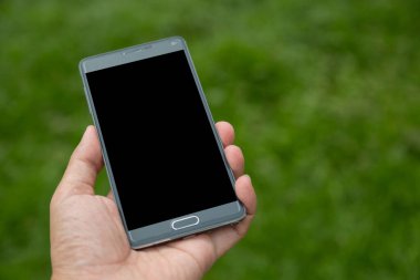 Elinde yeşil arkaplan olan akıllı telefon