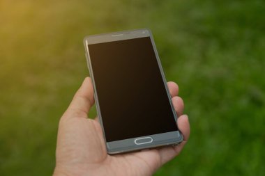 Elinde yeşil arkaplan olan akıllı telefon