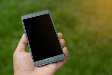 Elinde yeşil arkaplan olan akıllı telefon