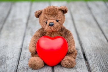 Esmer Ayı ve Kızıl Kalp Aşkına dikkat etmek için eski ahşap arka planda