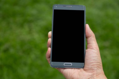 Elinde yeşil arkaplan olan akıllı telefon
