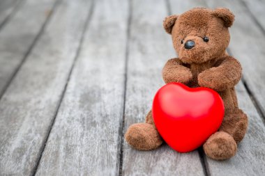 Esmer Ayı ve Kızıl Kalp Aşkına dikkat etmek için eski ahşap arka planda