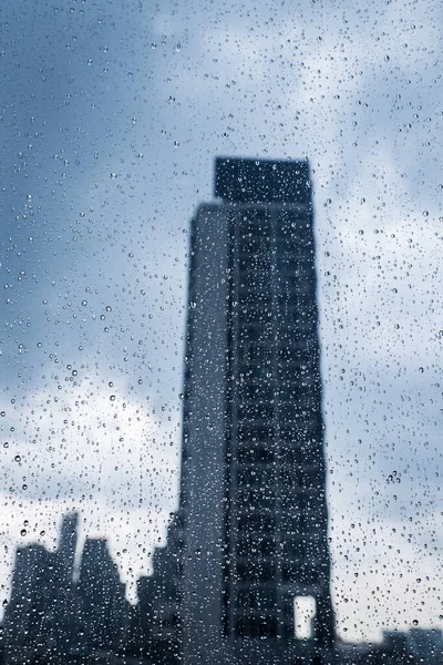 近代的なオフィスビルの背景を持つ汚れたガラス窓に雨の抽象的なイメージが落ちる — ストック写真