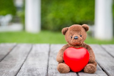 Esmer Ayı ve Kızıl Kalp Aşkına dikkat etmek için eski ahşap arka planda