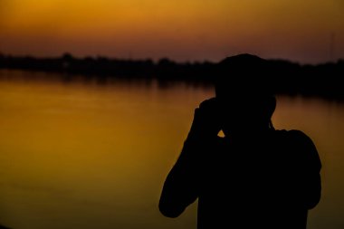 Gün batımından önce fotoğraf çeken bir adamın sessizliği