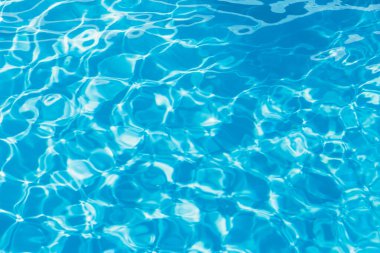 Güneşi yansıtan mavi havuz suyu