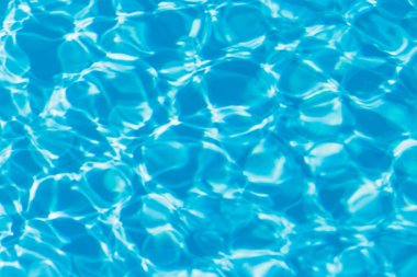 Güneşi yansıtan mavi havuz suyu