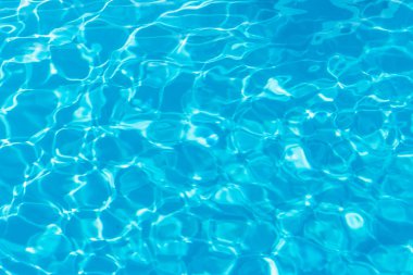 Güneşi yansıtan mavi havuz suyu