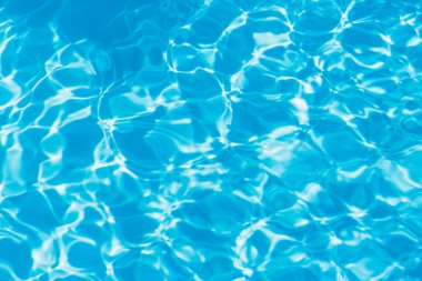 Güneşi yansıtan mavi havuz suyu