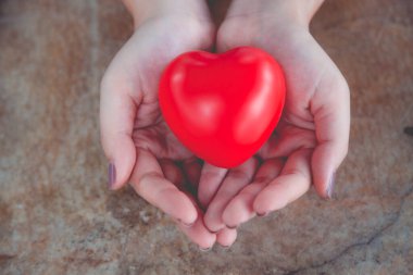 Kadın arka plan için kırmızı kalp kullanım tutun