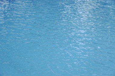 Mavi yüzme havuzu kenarında su dalgalanması var.