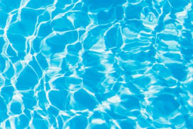 Güneşi yansıtan mavi havuz suyu