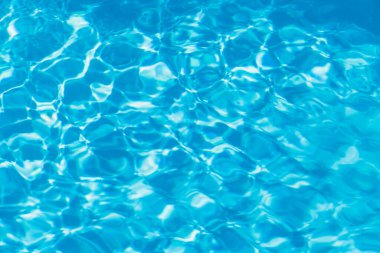 Güneşi yansıtan mavi havuz suyu