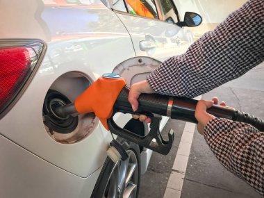 Benzin istasyonunda yakıt ikmali yapan kadın.