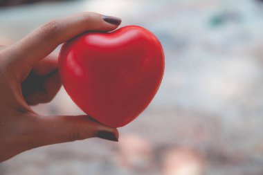 Kadın arka plan için kırmızı kalp kullanım tutun