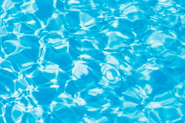 Güneşi yansıtan mavi havuz suyu