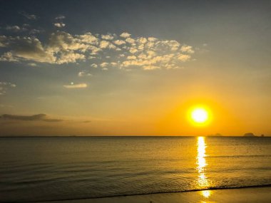 Sahilde gökyüzü ve gün batımından önce tekne.