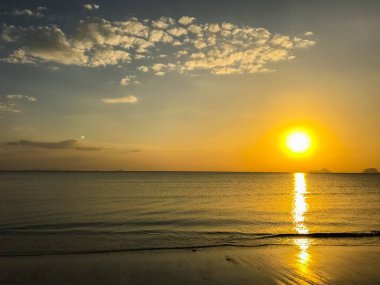 Sahilde gökyüzü ve gün batımından önce tekne.