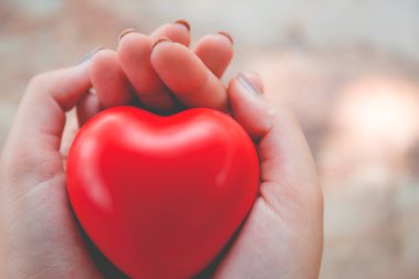 Kadın arka plan için kırmızı kalp kullanım tutun