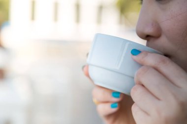 Arka planda bulanık kahve içen kadın.