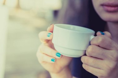 Arka planda bulanık kahve içen kadın.