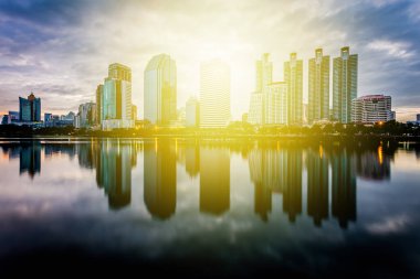 Gün batımı arka plan önce su yansıması ile bina şehir