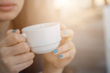 Arka planda bulanık kahve içen kadın.