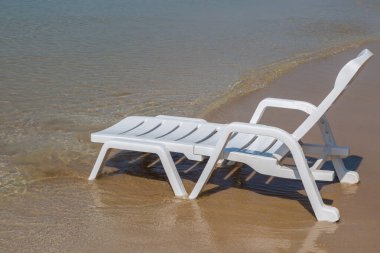 Plaj arka planında güneşli sahilde plaj sandalyesi