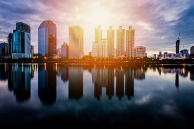 Gün batımı arka plan önce su yansıması ile bina şehir