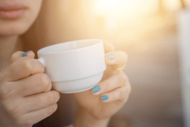 Arka planda bulanık kahve içen kadın.