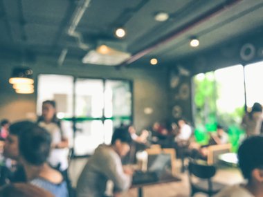 Kafede arka planda bir sürü müşterinin bulanık görüntüsü.