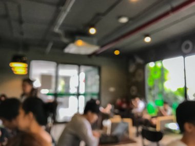 Kafede arka planda bir sürü müşterinin bulanık görüntüsü.