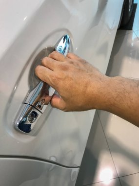 Adamın eli arabanın arka kapısını açıyor.