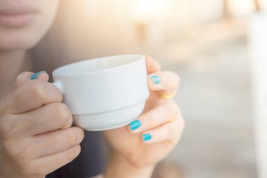 Arka planda bulanık kahve içen kadın.