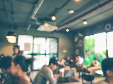 Kafede arka planda bir sürü müşterinin bulanık görüntüsü.