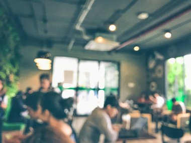 Kafede arka planda bir sürü müşterinin bulanık görüntüsü.