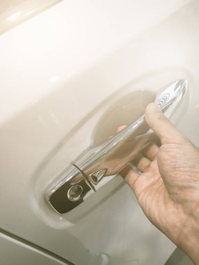 Adamın eli arabanın arka kapısını açıyor.