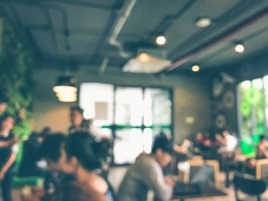 Kafede arka planda bir sürü müşterinin bulanık görüntüsü.