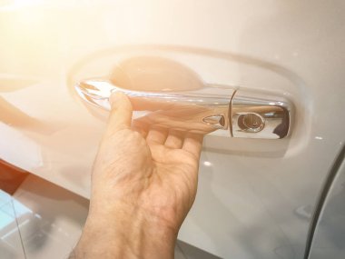 Adamın eli arabanın arka kapısını açıyor.