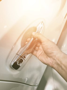 Adamın eli arabanın arka kapısını açıyor.