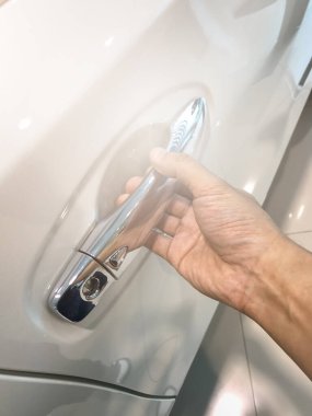 Adamın eli arabanın arka kapısını açıyor.