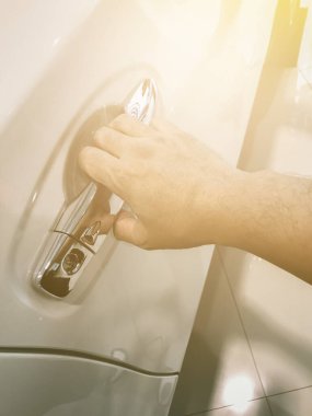 Adamın eli arabanın arka kapısını açıyor.