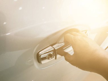 Adamın eli arabanın arka kapısını açıyor.